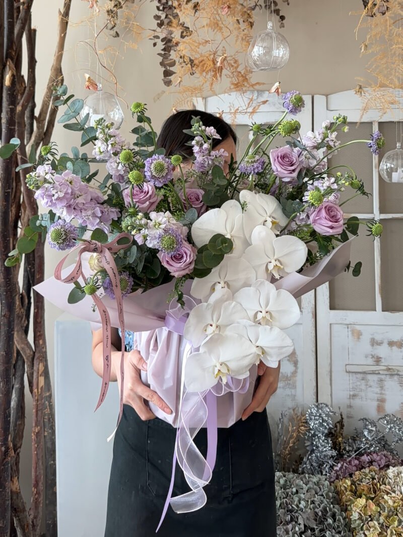 Full view of Lilac Garden Bloom Box with white orchids and lavender flowers
