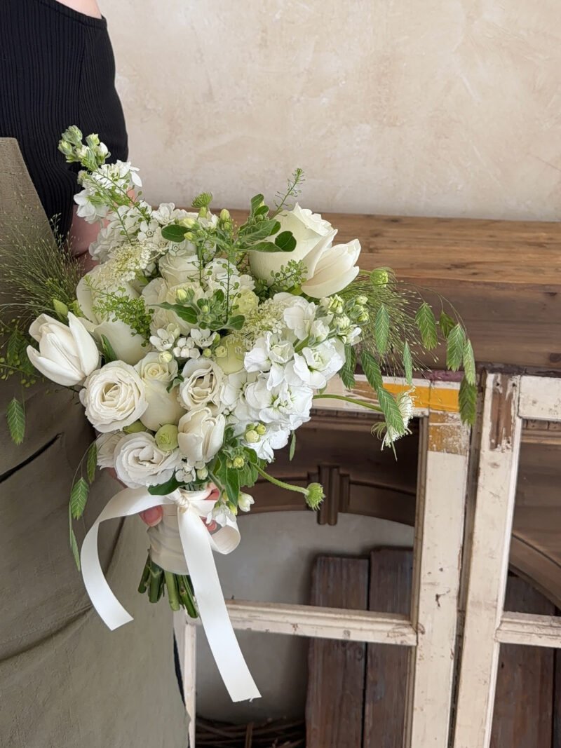 Full view of Pure Love white bridal bouquet with roses, tulips and garden-style foliage