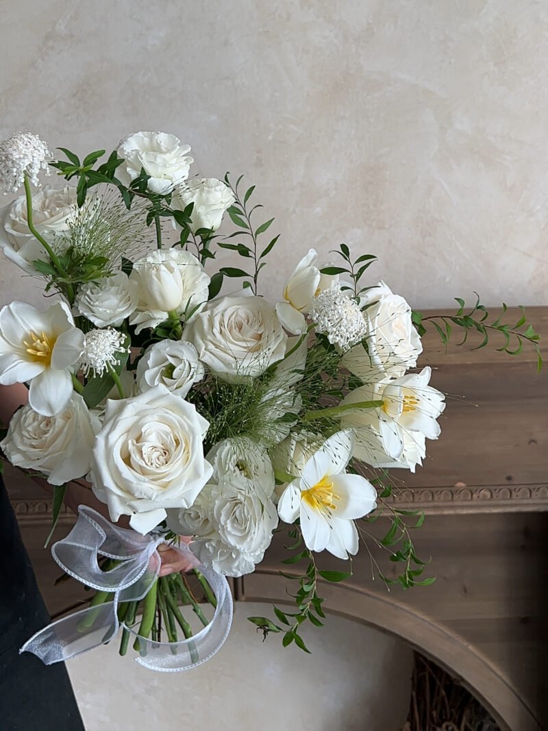 Full view of Romance White bridal bouquet with roses, tulips and seasonal foliage