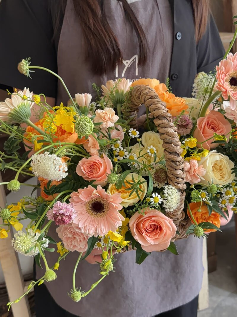 Front view of the Rosy Sunset orange garden-style flower basket