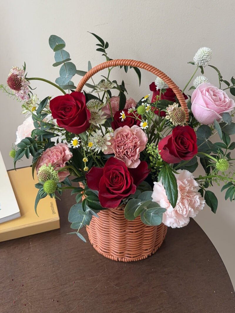 Front view of the Scarlet Bloom flower basket with red roses and pink flowers